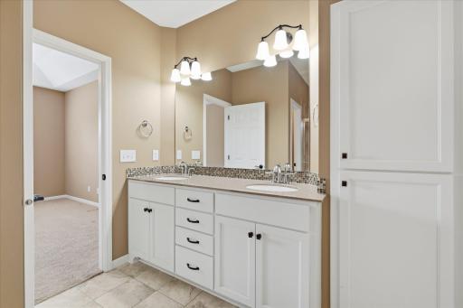 Another primary bath view also showing large linen storage