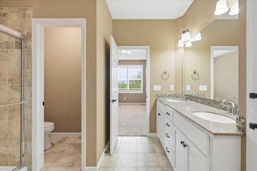 Primary bath showing the large double sink vanity with enameled cabinets and woodwork. ceramic floors, and private stool area