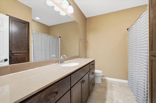 Lower level full bath has a huge vanity with lots of cabinet space, tub/shower and linen storage