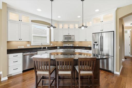 The kitchen features under cabinet lighting to highlight the granite counters, and all across the upper lighted display cabinets
