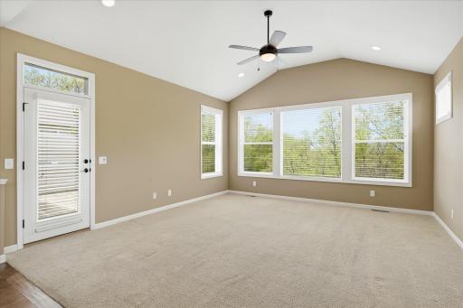 great room with vaulted cathedral ceiling and huge windows looking out to the preserve area in the back