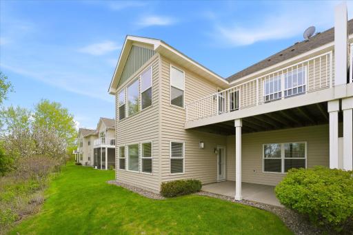 Exterior view from the back showing the large lower level patio and the main level deck