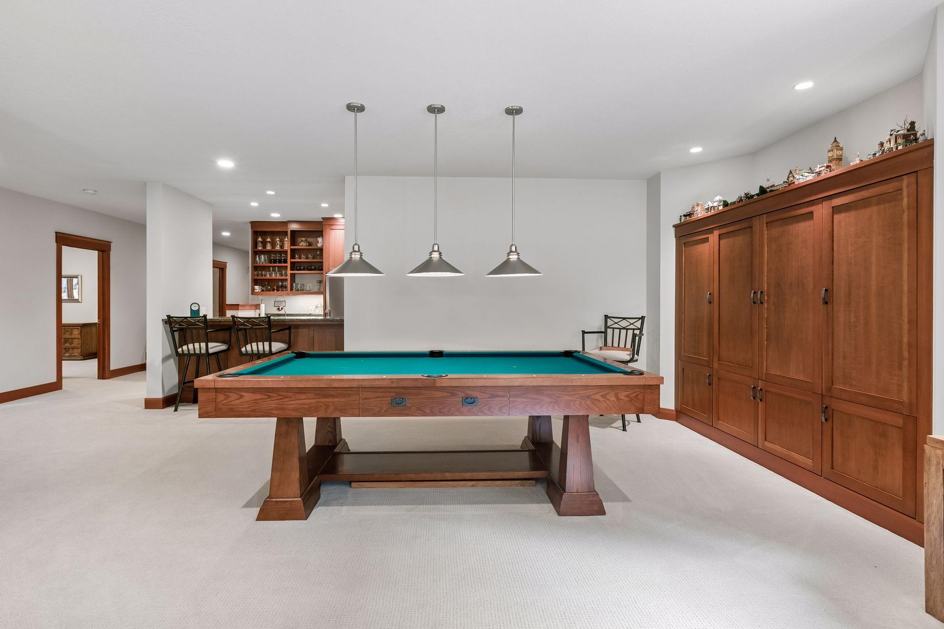 Spacious billiards area with custom built-ins, seamlessly connected to the lower-level family room.