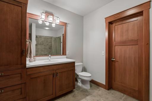 Lower-level full bath serves as a private en suite to the fourth bedroom while also offering convenient hallway access.