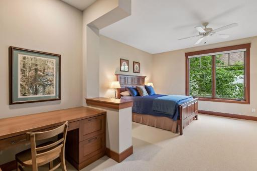 Bedroom 2 offers custom built-ins, including a desk and bookcases, plus a walk-in closet.