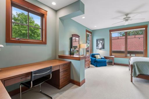 Bedroom 3 featuring custom built-in desk, bookcases, and a walk-in closet.