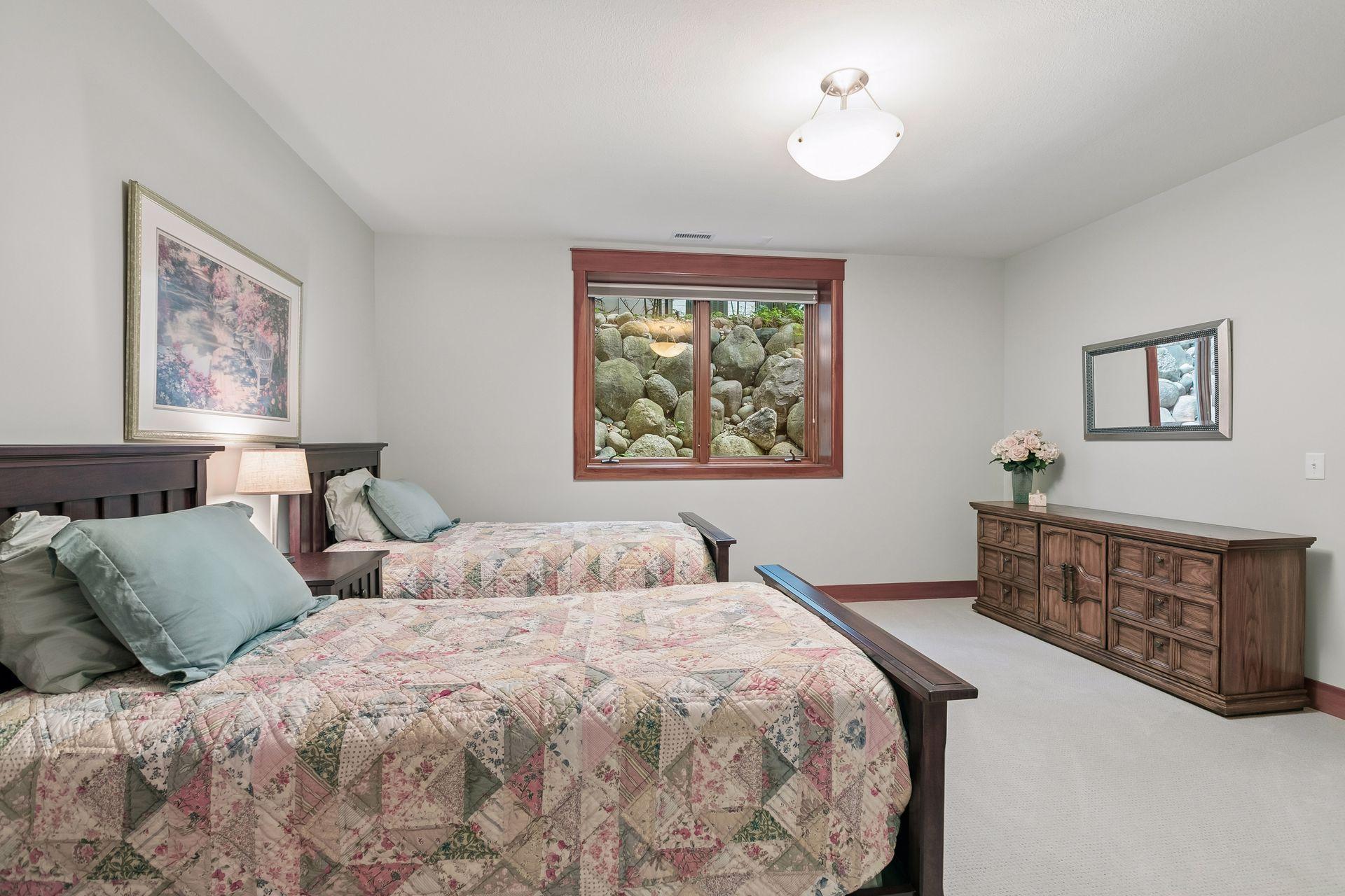 Lower-level fourth bedroom with an en suite full bath leading to a walk-in closet.