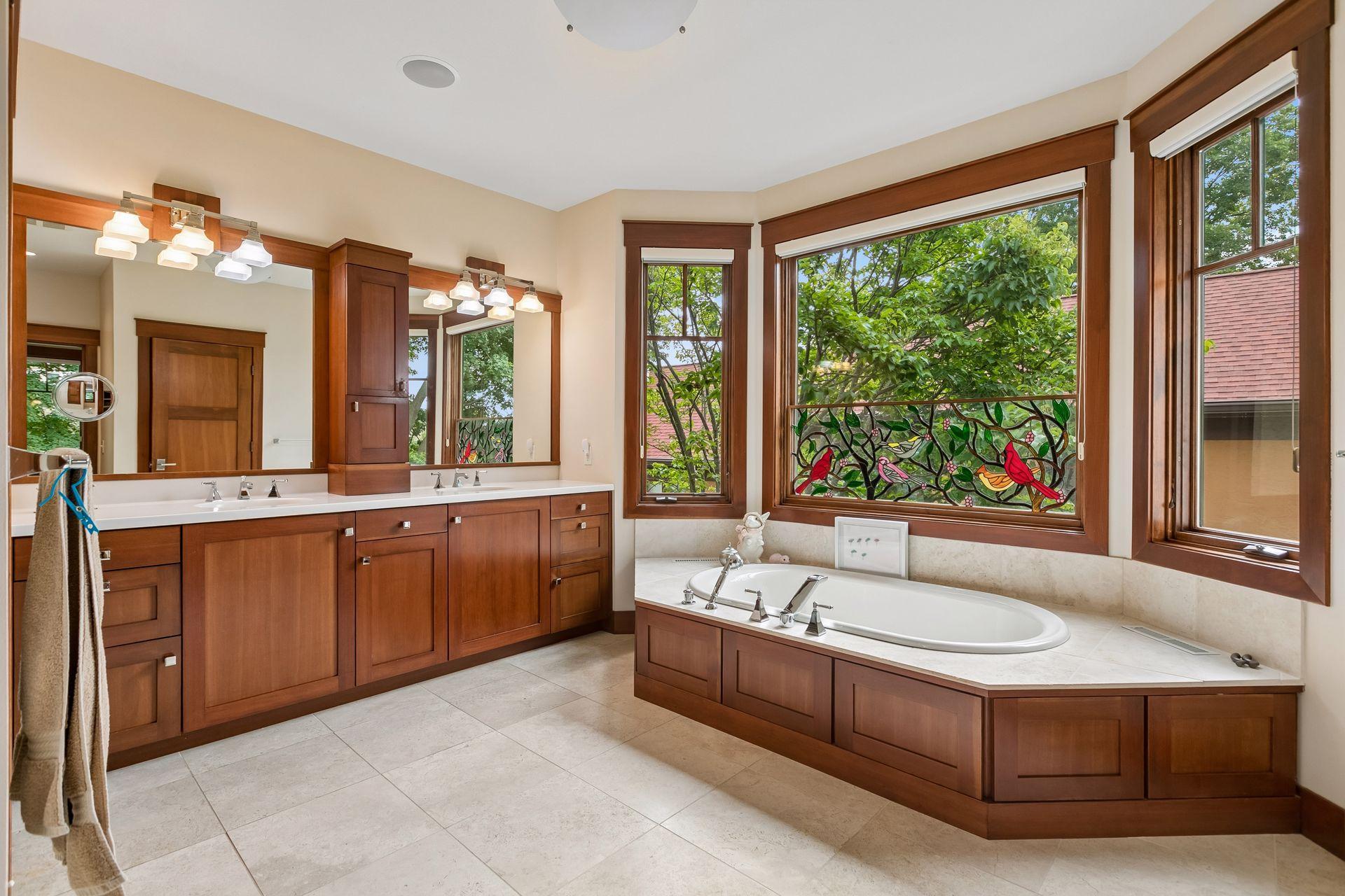 Spa-inspired primary bath featuring a double vanity, soaking tub, and in-floor heat.