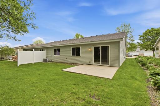 Private backyard with a spacious lawn and concrete patio, accessible through sliding glass doorsâperfect for outdoor relaxing and entertaining.