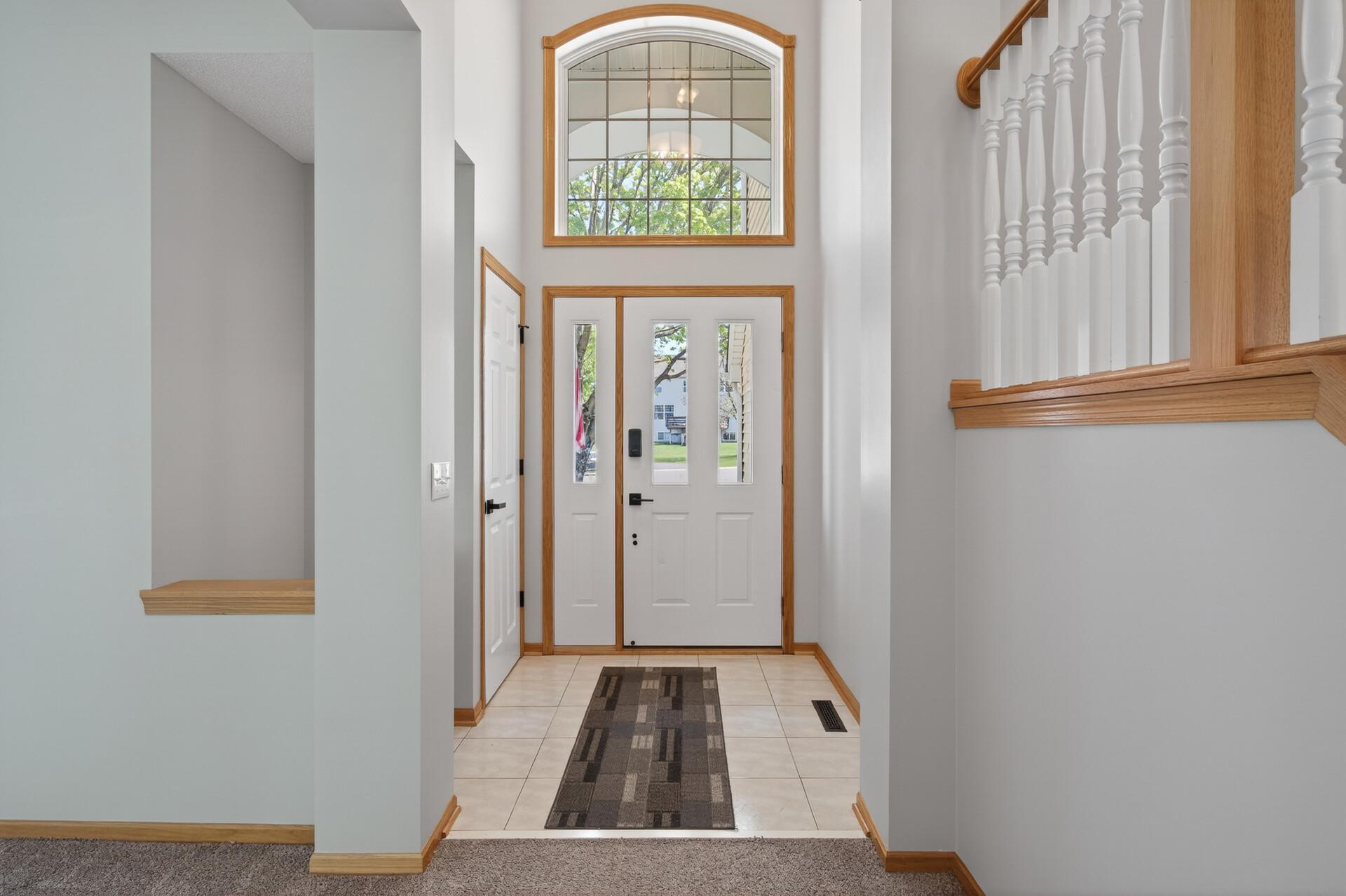 Bright and airy foyer with soaring ceilings and abundant natural light.