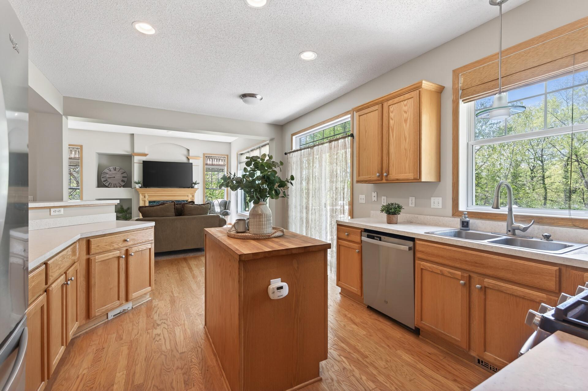Bright and functional kitchen featuring abundant cabinetry, center island, and scenic backyard views.