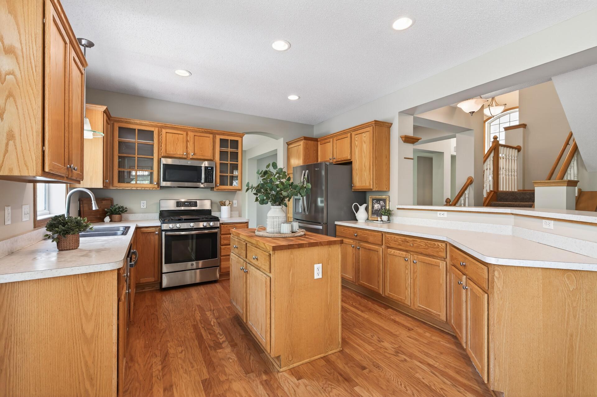 Well-appointed kitchen with hardwood floors, stainless steel appliances, and extensive counter space.