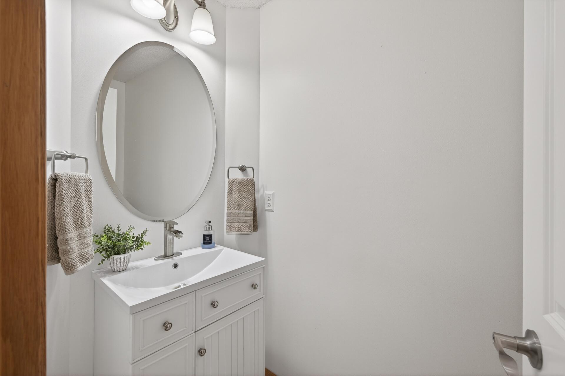 Updated main-level powder room with modern vanity, fixtures, and fresh finishes.