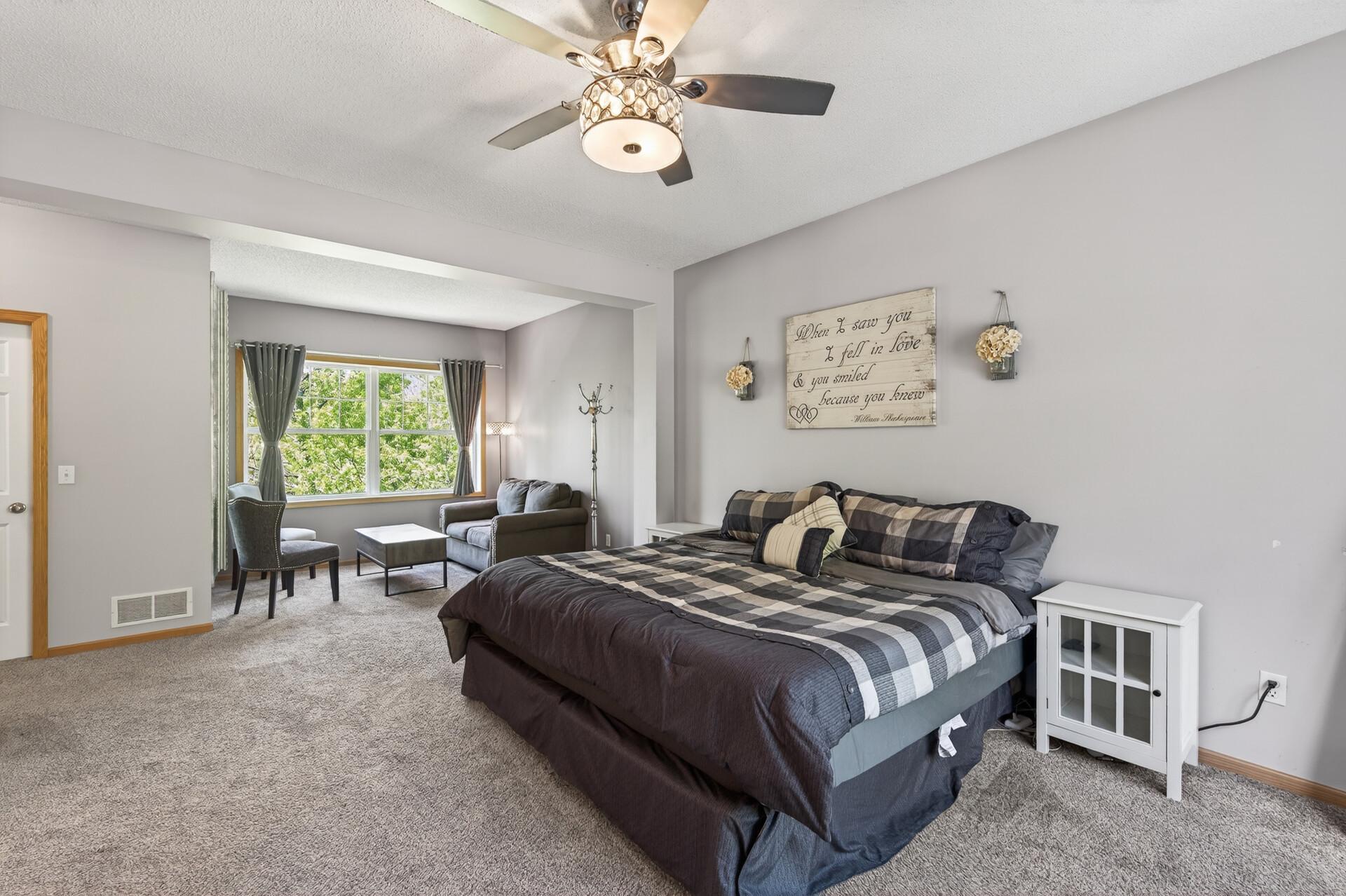 Expansive owner’s suite with sitting area, large windows, and generous space to unwind.
