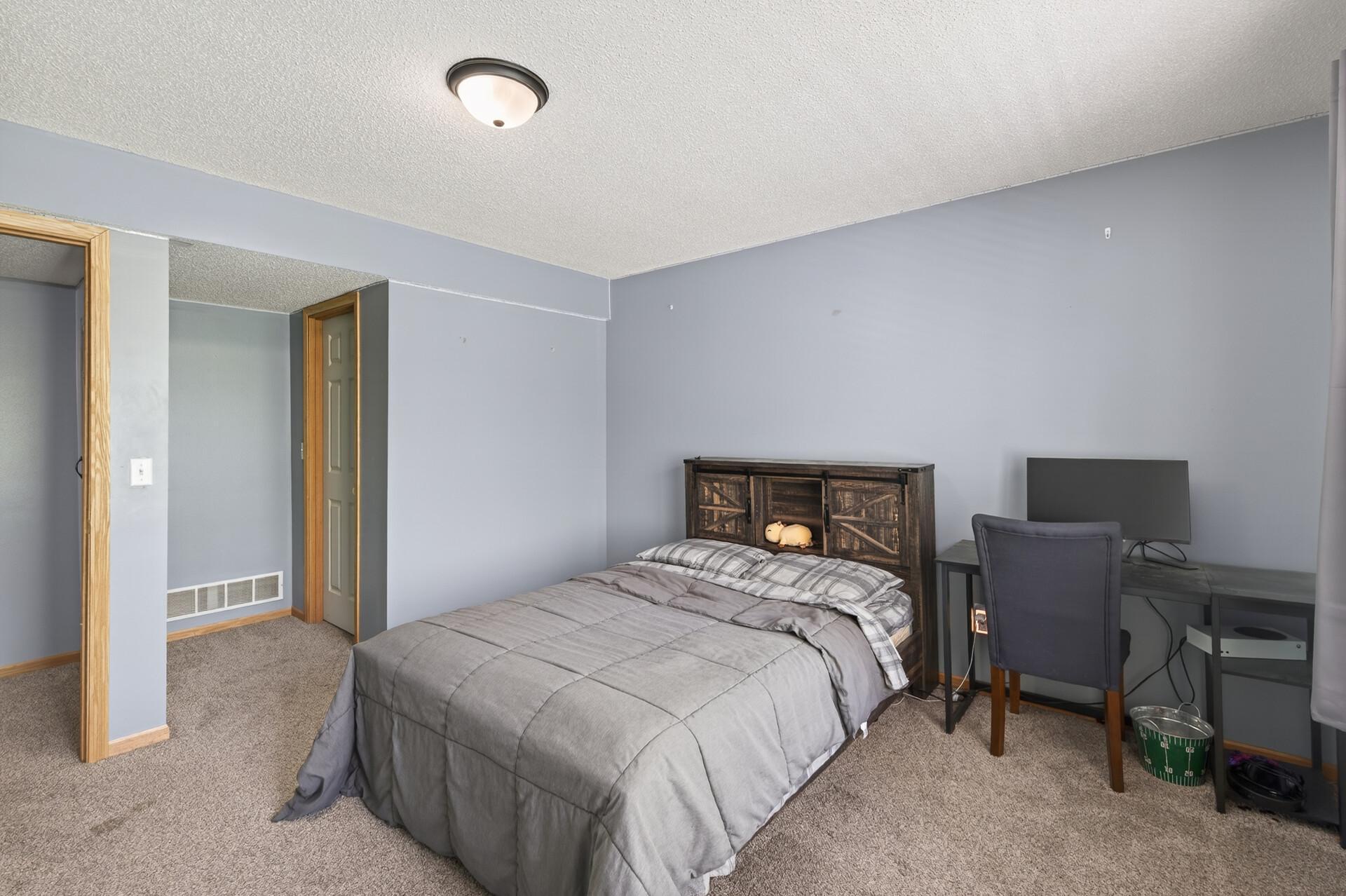 Generously sized bedroom featuring updated carpeting and space for a study or work area.