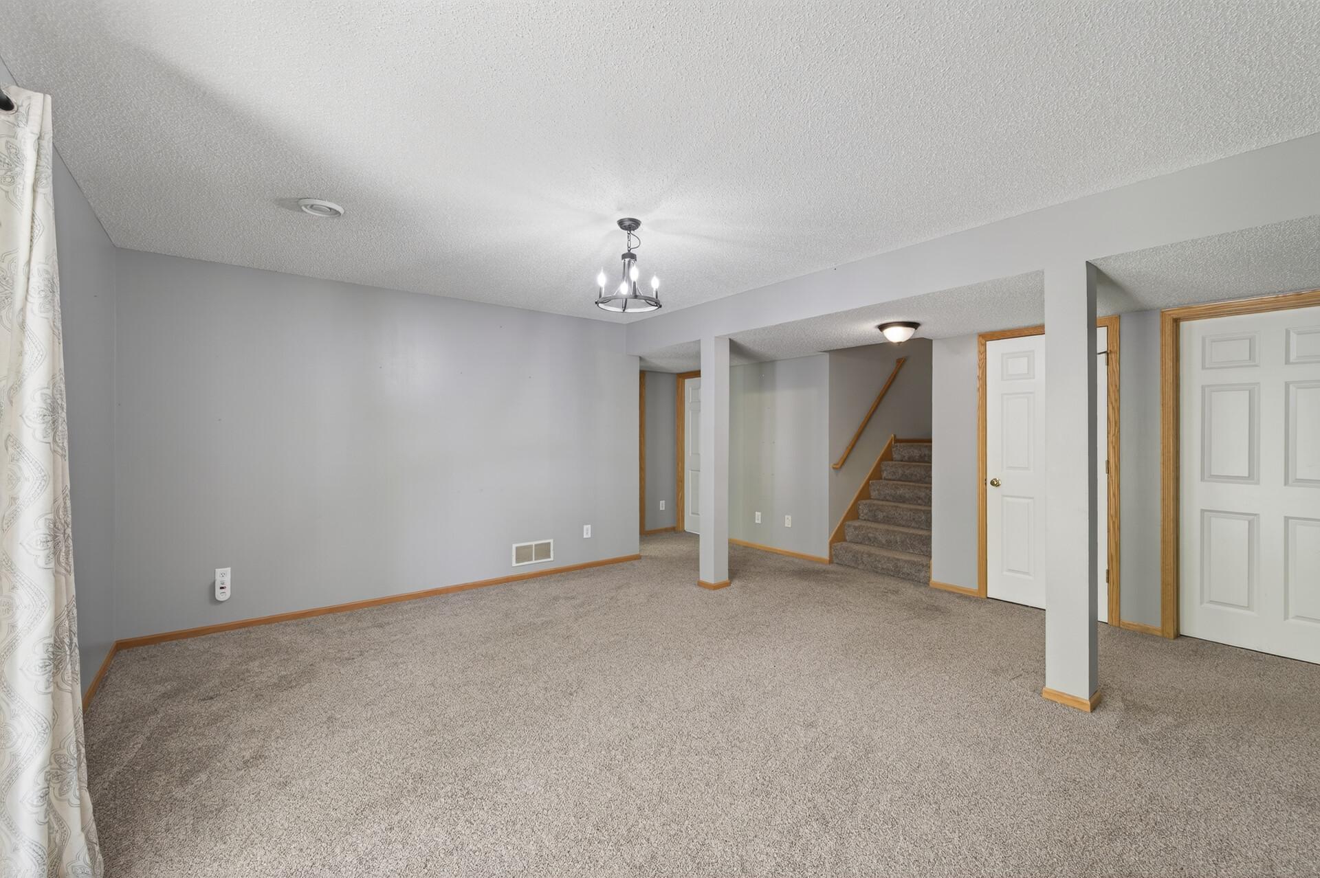 Spacious lower-level amusement room with convenient stair access and flexible living space.
