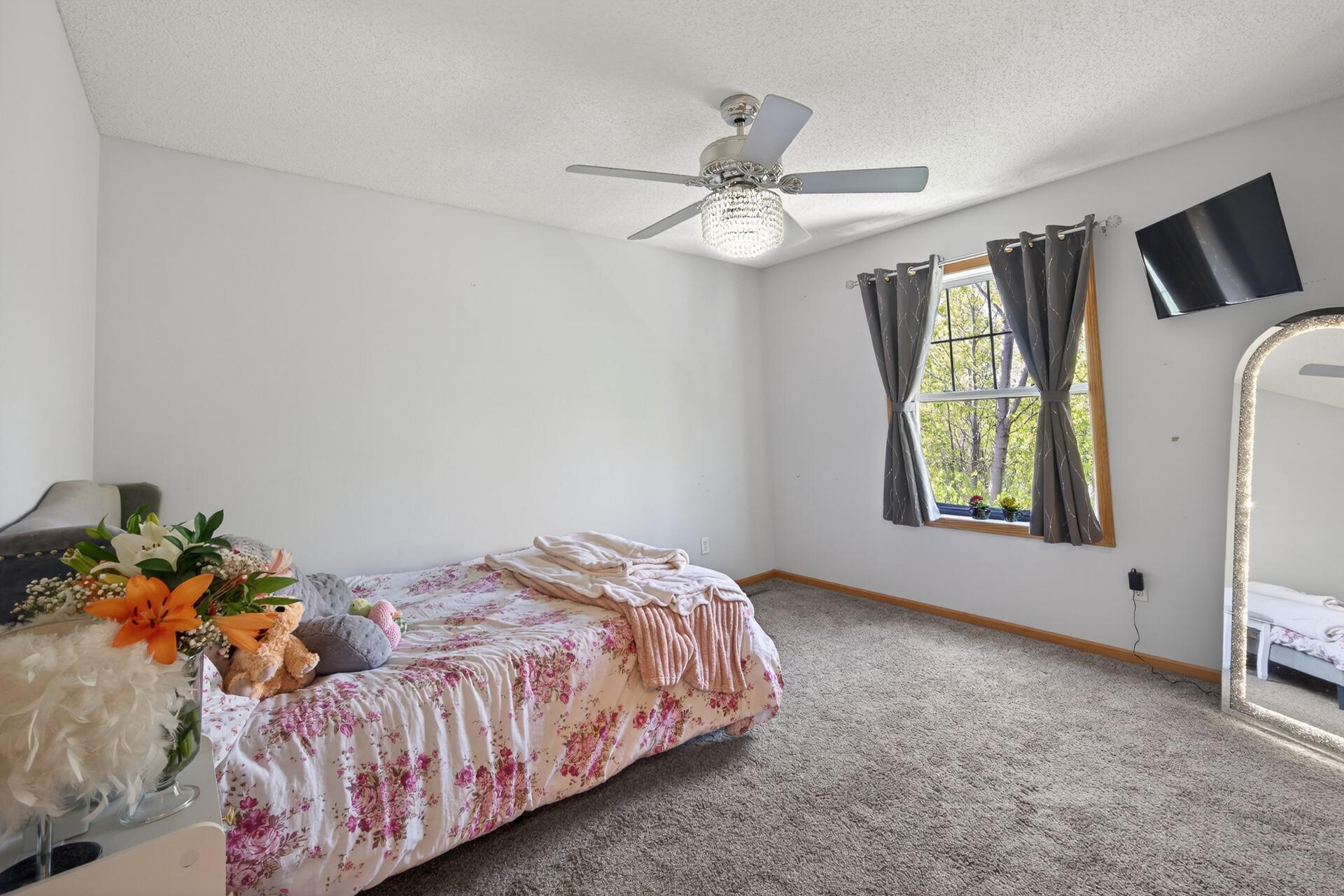 Comfortable secondary bedroom with stylish finishes and peaceful backyard views.