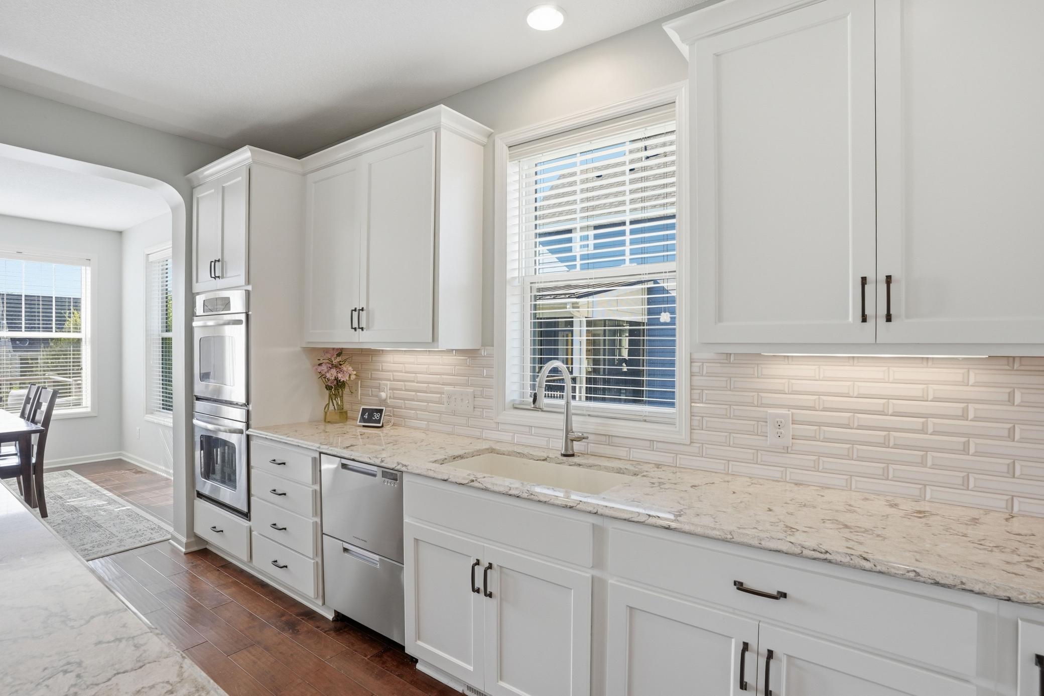 Farmhouse sink, quartz countertops, and a stylish tile backsplash.