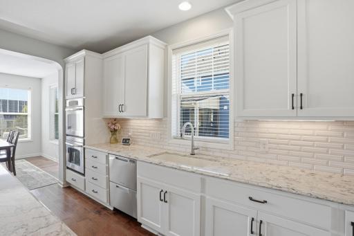 Farmhouse sink, quartz countertops, and a stylish tile backsplash.