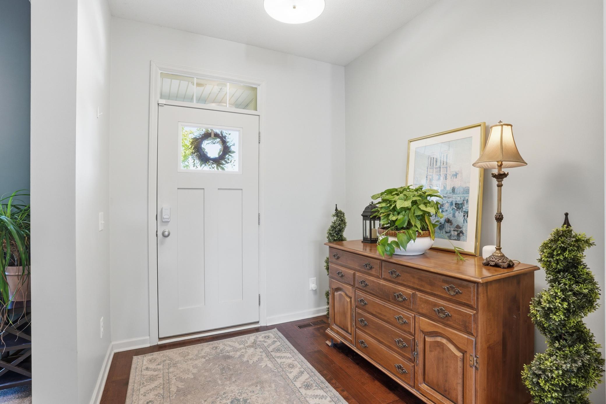 Bright and welcoming front entry with warm hardwood floors.