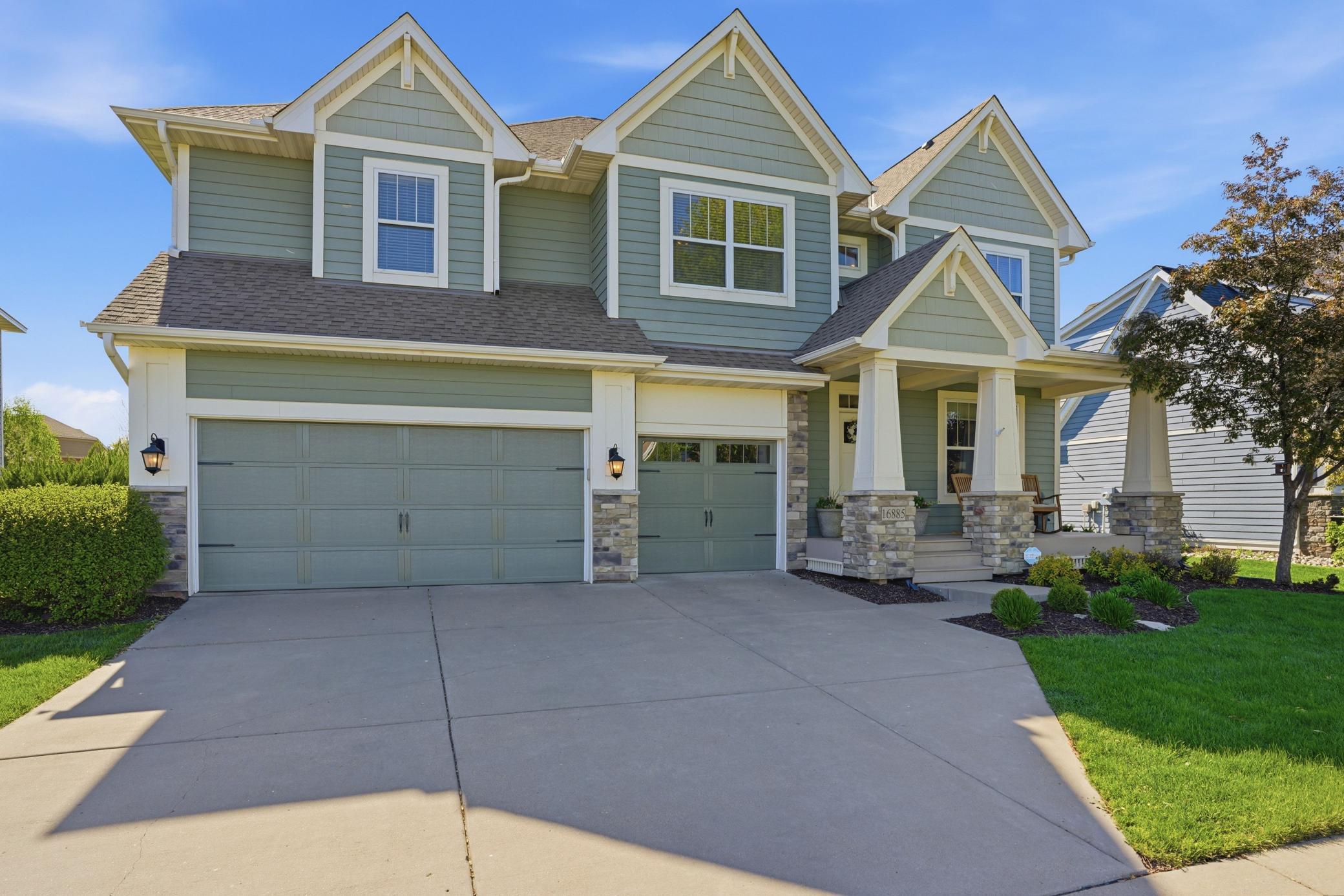 Beautiful exterior with charming front porch and spacious 3-car garage.