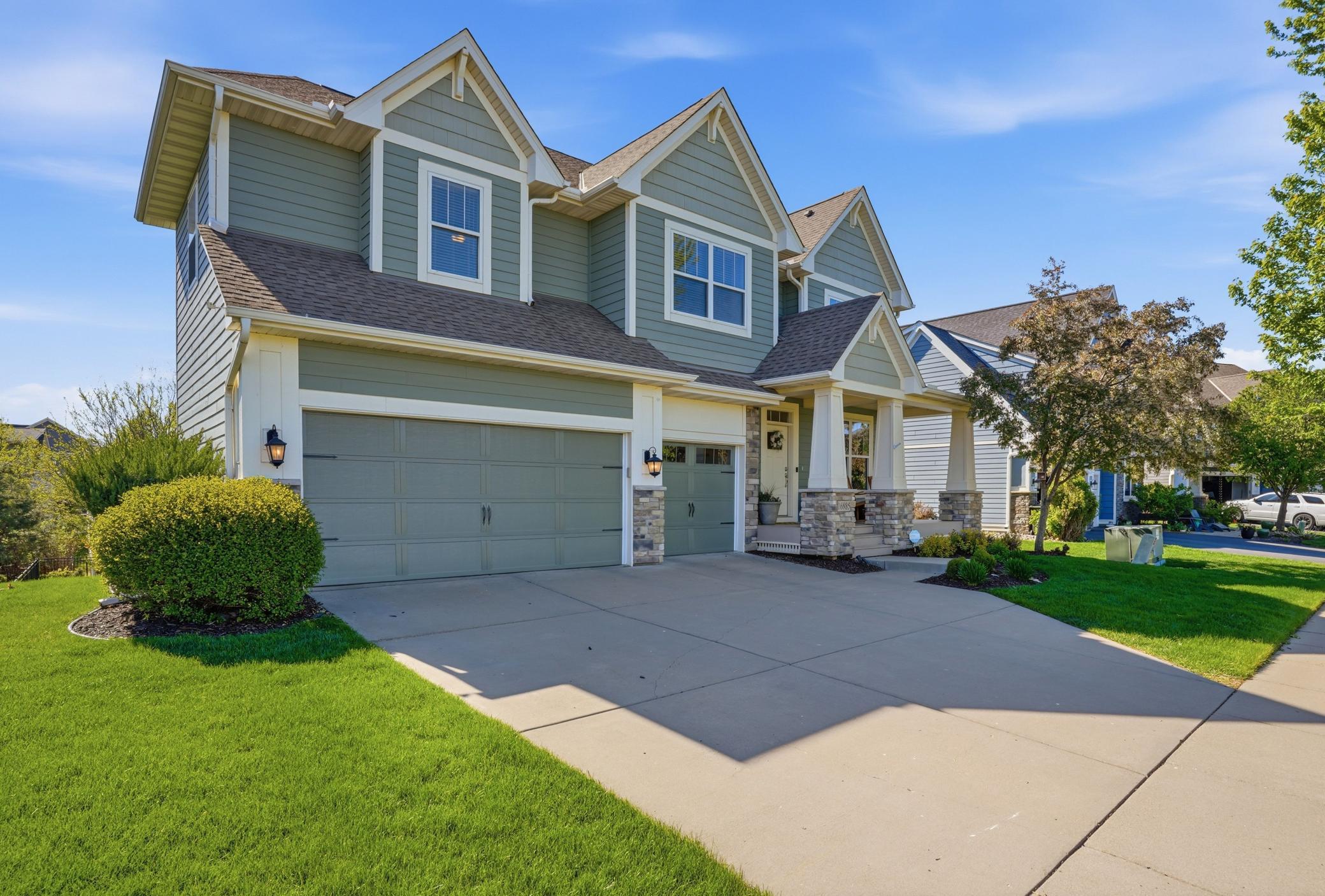 Spacious concrete driveway and attractive exterior details add to the home’s curb appeal.