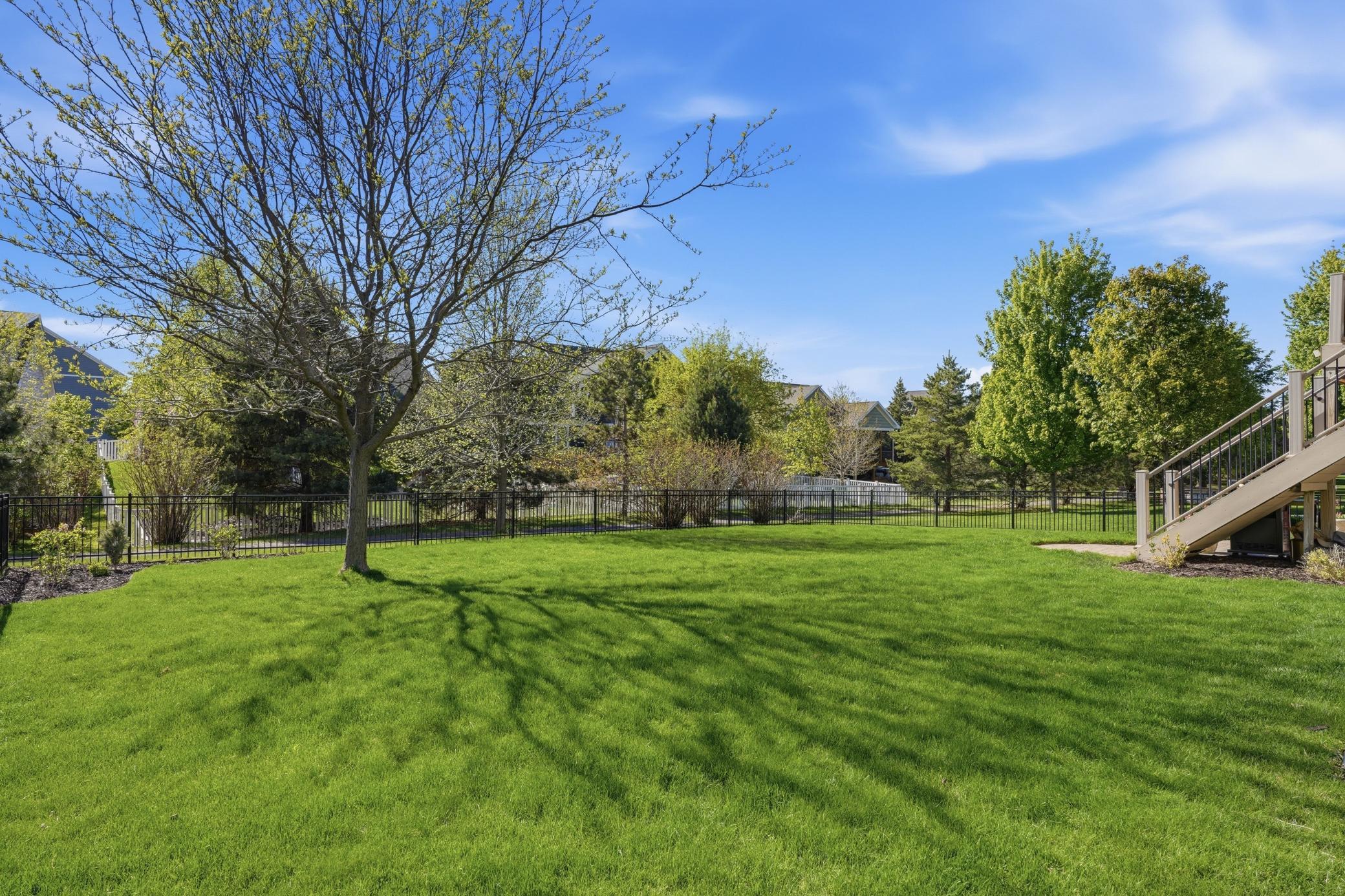 Deck stairs lead down to the fully fenced backyard backing to walking paths with plenty of room to play, relax, or entertain.