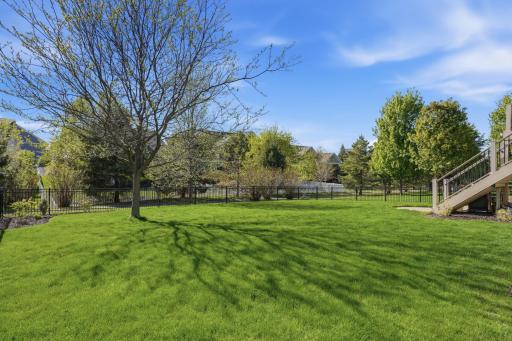 Deck stairs lead down to the fully fenced backyard backing to walking paths with plenty of room to play, relax, or entertain.