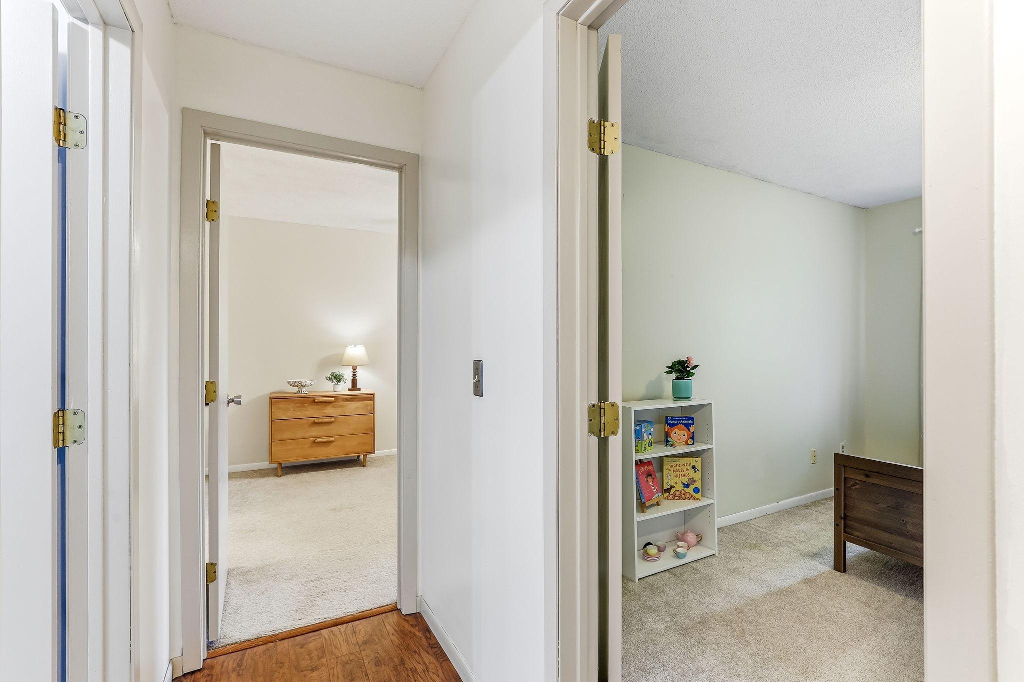 Interior hallway connecting upper-level bedrooms with updated flooring, bright neutral finishes, and functional split-level design in this well-maintained Inver Grove Heights townhome near parks and schools.