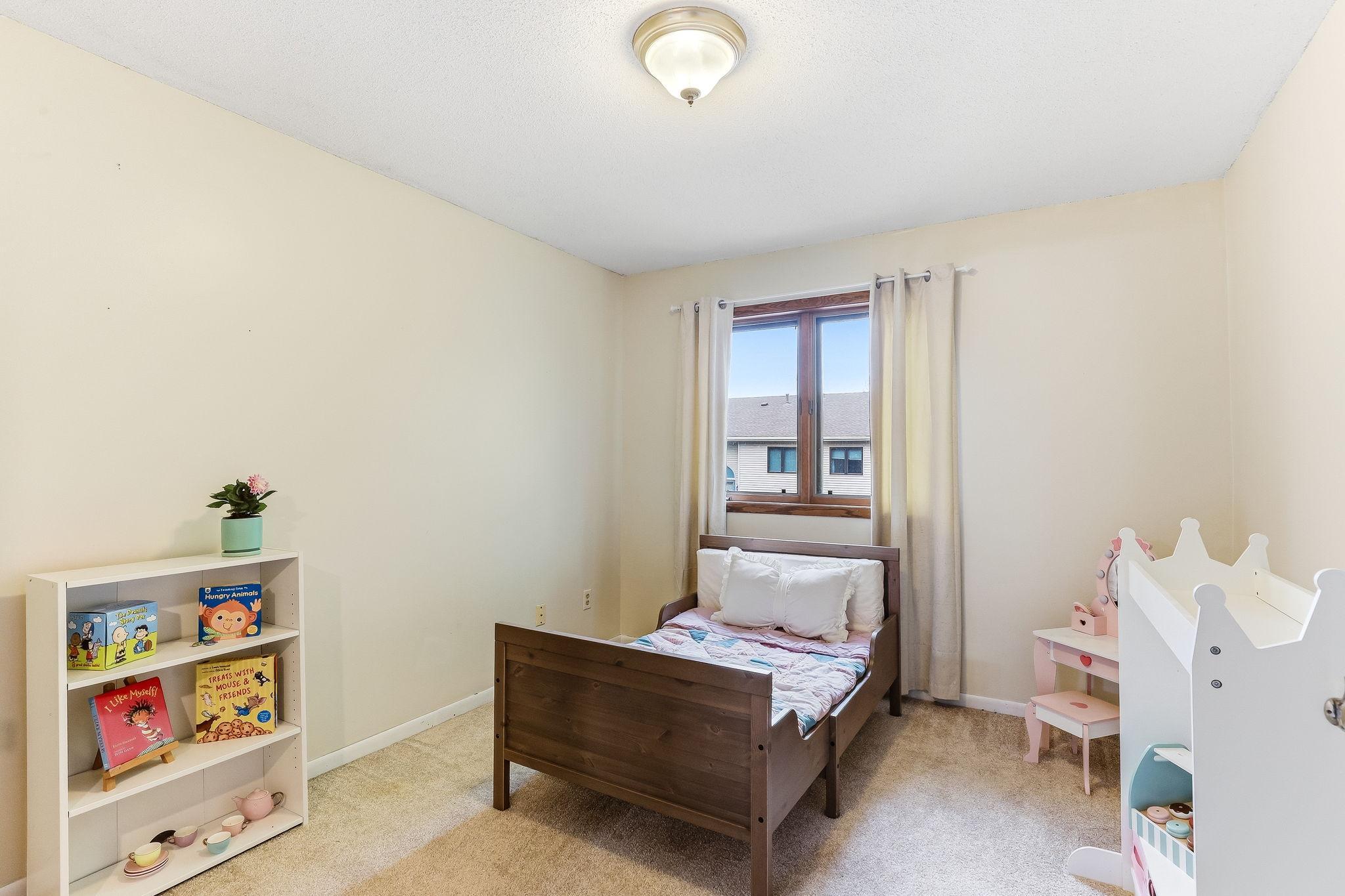 Spacious secondary bedroom in this Inver Grove Heights townhome featuring soft natural light, neutral finishes, updated carpet, and flexible space ideal for living, guests, or home office use.
