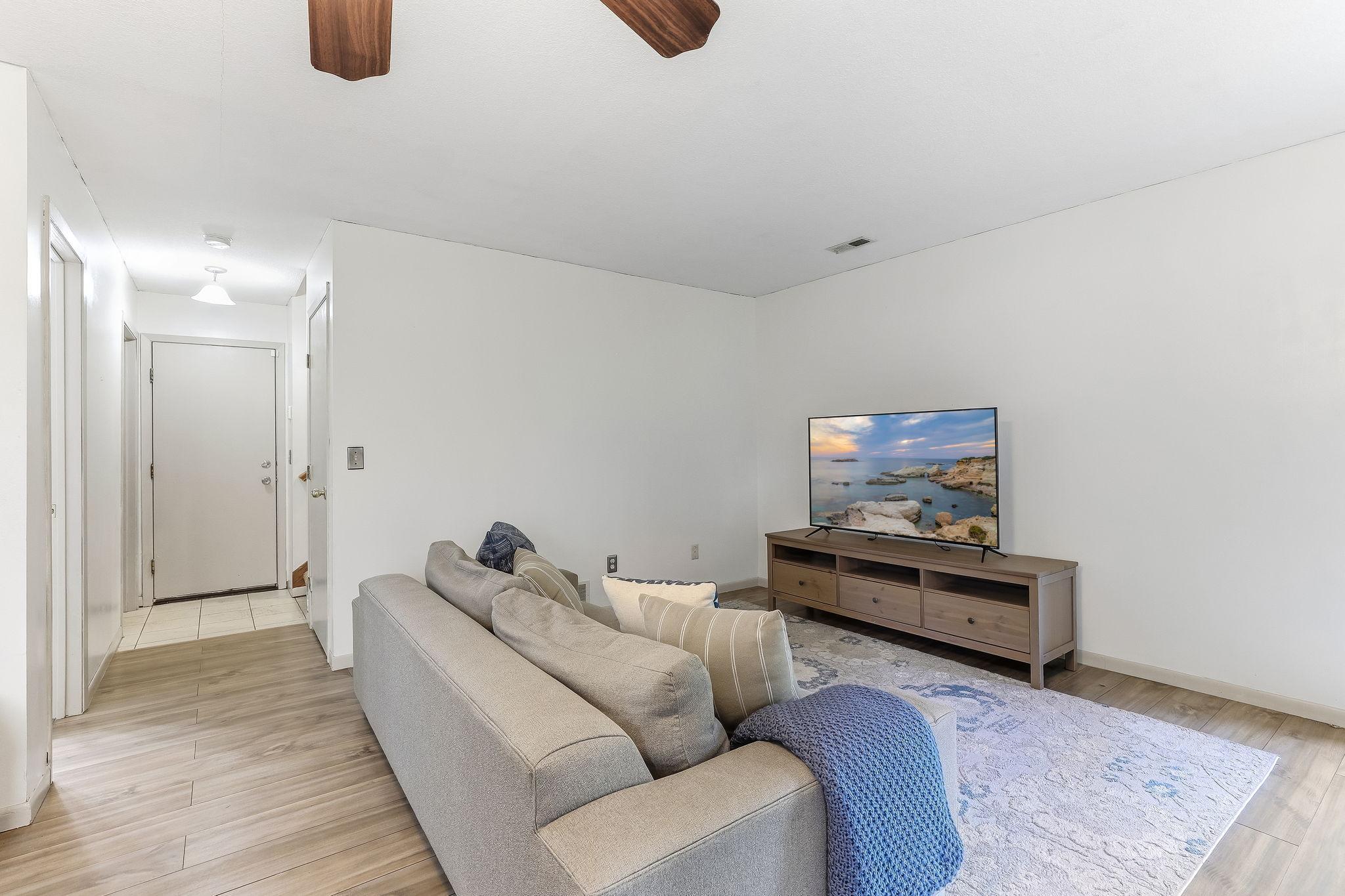 Lower-level living room with ample space for media setup and everyday gathering, offering a comfortable extension of the home’s main living areas.
