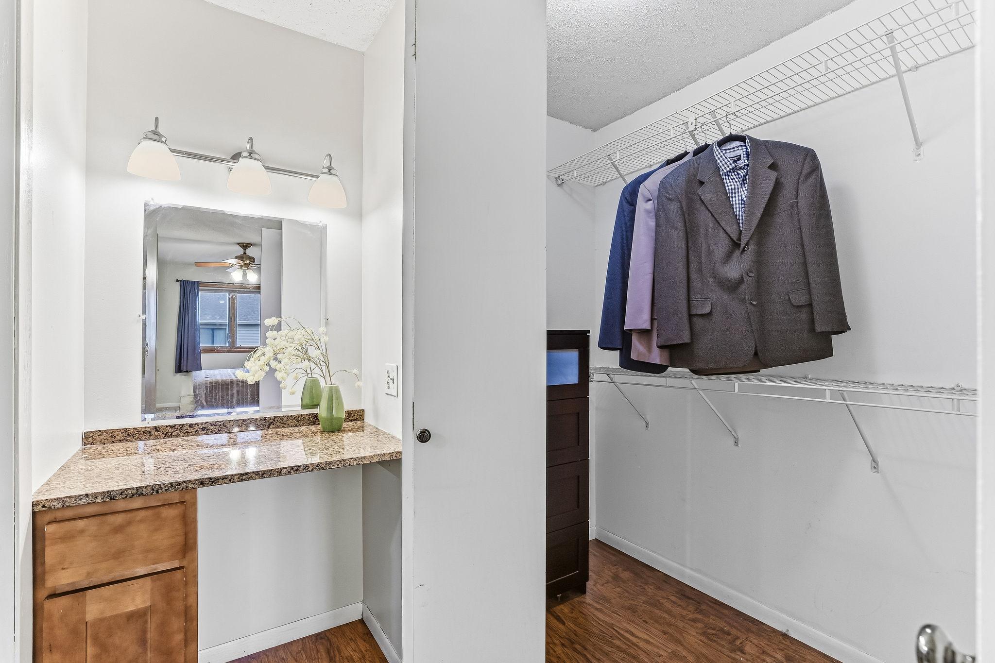 Closet and separate vanity area in the primary suite offering organized storage, functional layout, and comfortable living space in this Inver Grove Heights townhome with low-maintenance HOA living.