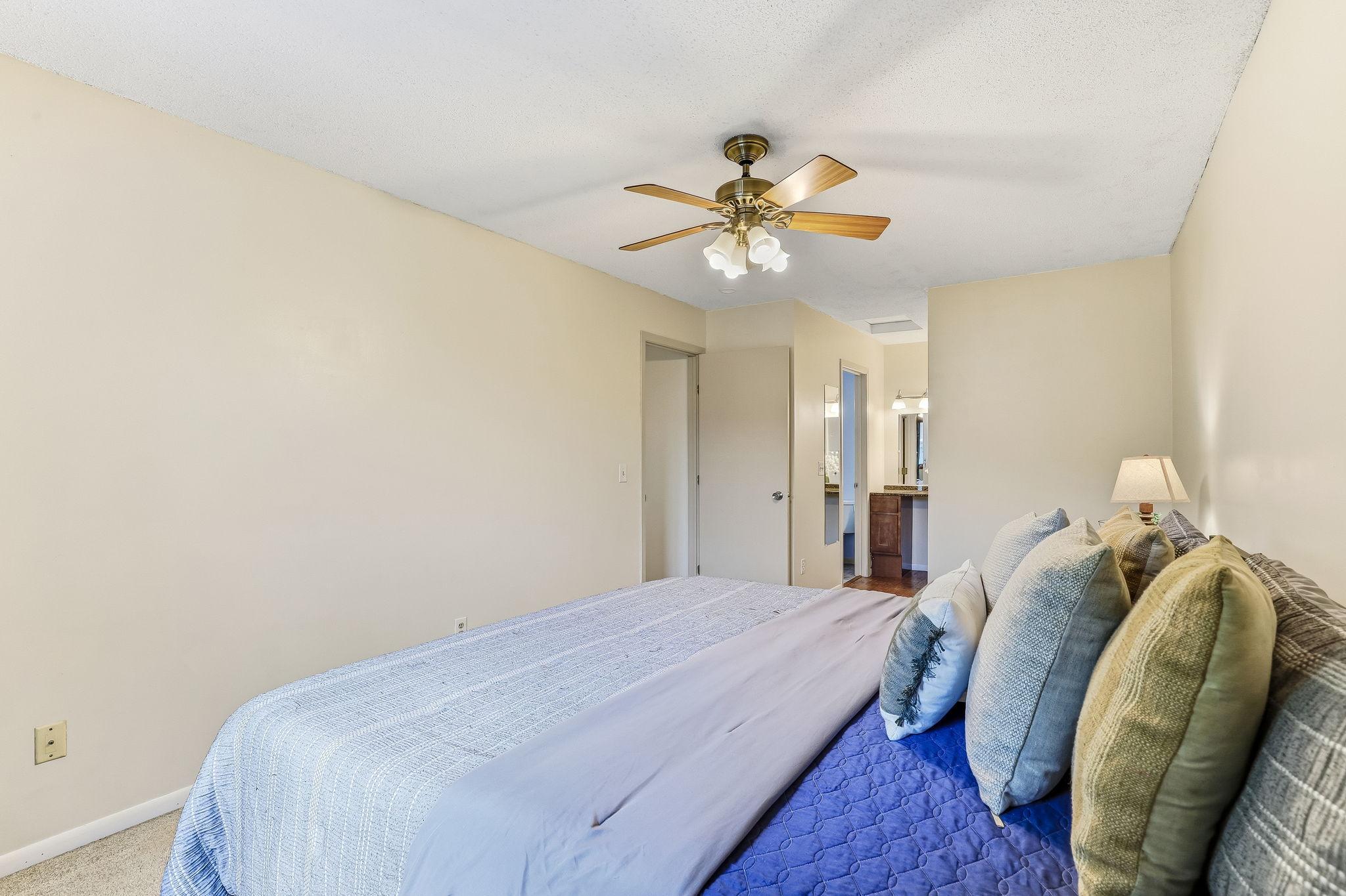 Alternate view of the primary bedroom highlighting the expansive layout, neutral finishes, and direct connection to the private dressing and bathroom area.
