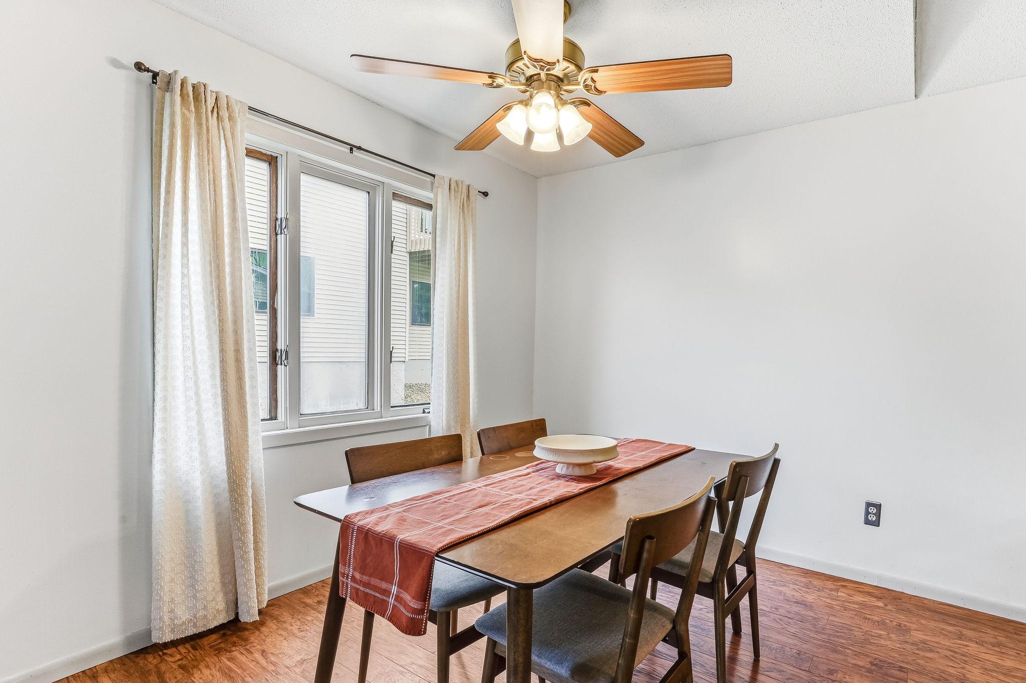 Dedicated dining space in this move-in ready Inver Grove Heights townhome featuring updated flooring, oversized window, natural light, and convenient flow to the kitchen and living room for easy everyday living and entertaining.