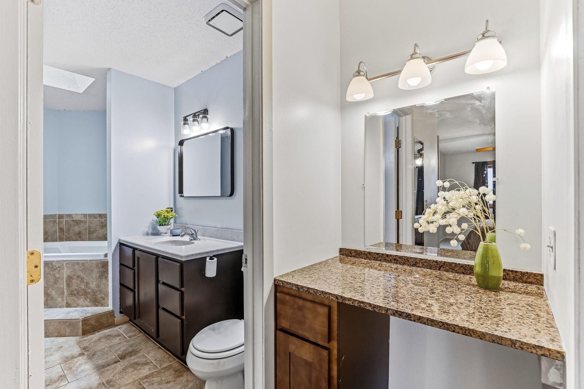 Full bathroom layout at 7653 Borman Way featuring a single-sink vanity, separate makeup/prep counter area, oversized soaking tub, and functional everyday convenience in this Inver Grove Heights townhome.