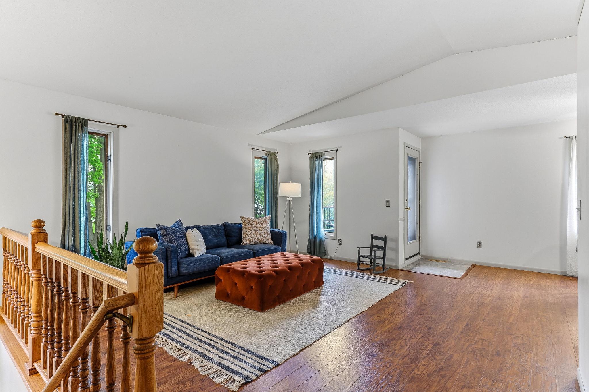 Bright and inviting living room in this Inver Grove Heights townhome featuring updated flooring, vaulted ceilings, large windows, and an open-concept layout designed for comfortable everyday living and entertaining near the Twin Cities.