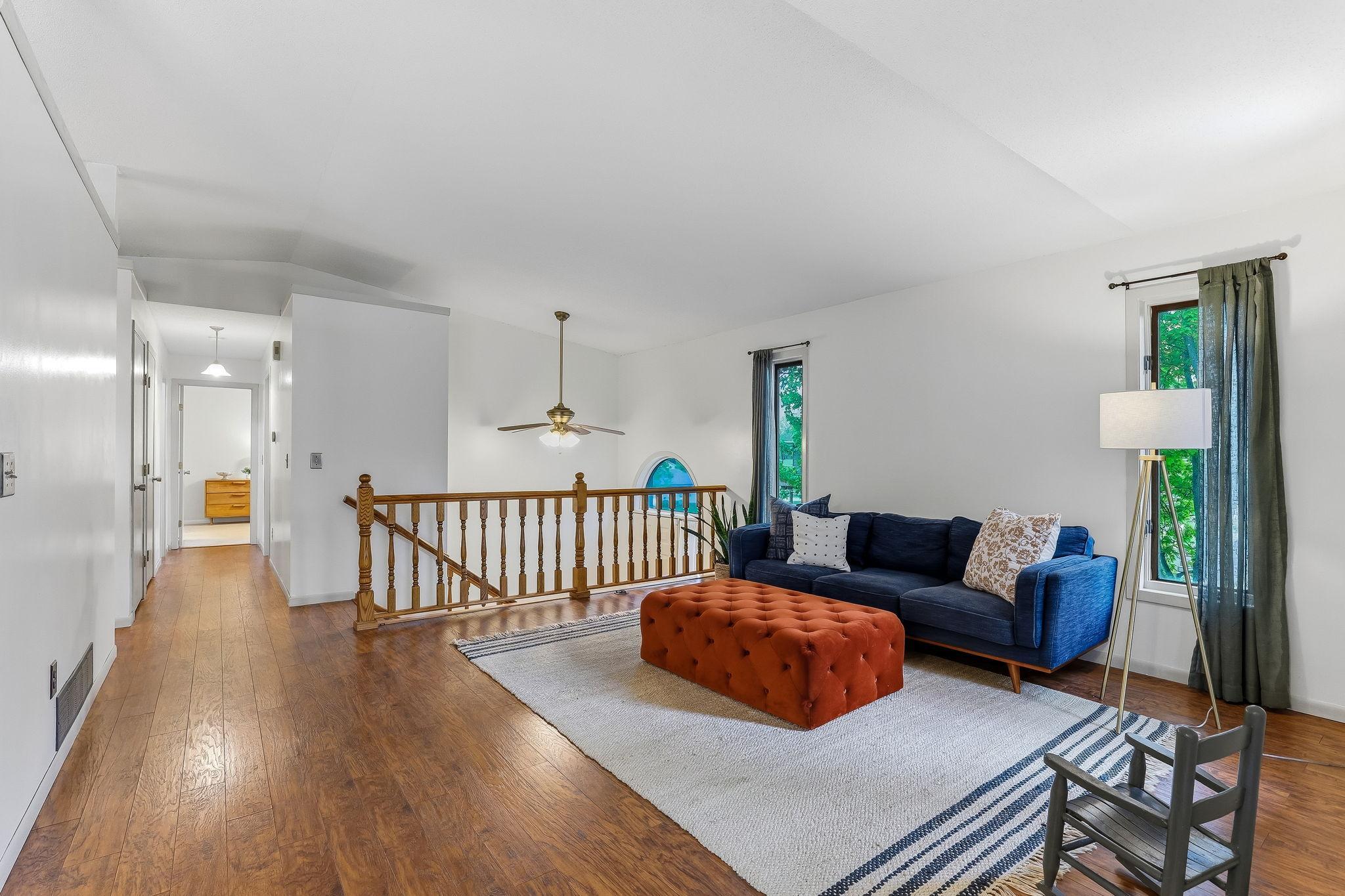 Spacious upper-level living room in this Inver Grove Heights townhome featuring updated flooring, vaulted ceilings, oversized windows, and an open-concept layout filled with natural light and flexible entertaining space near St. Paul.