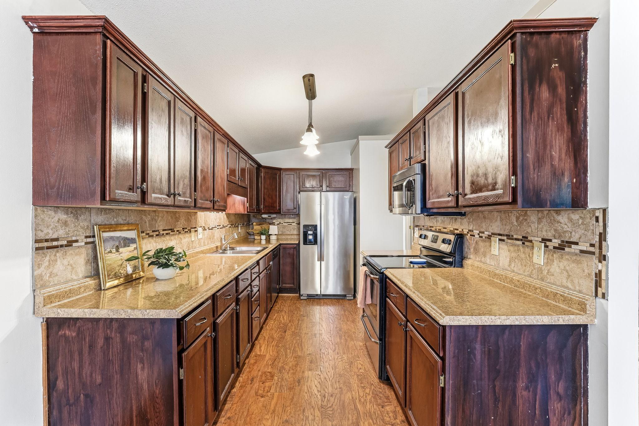 Bright and functional kitchen with rich wood cabinetry, updated finishes, open flow to dining and living spaces, and move-in ready convenience in this well-maintained Inver Grove Heights townhome near St. Paul.