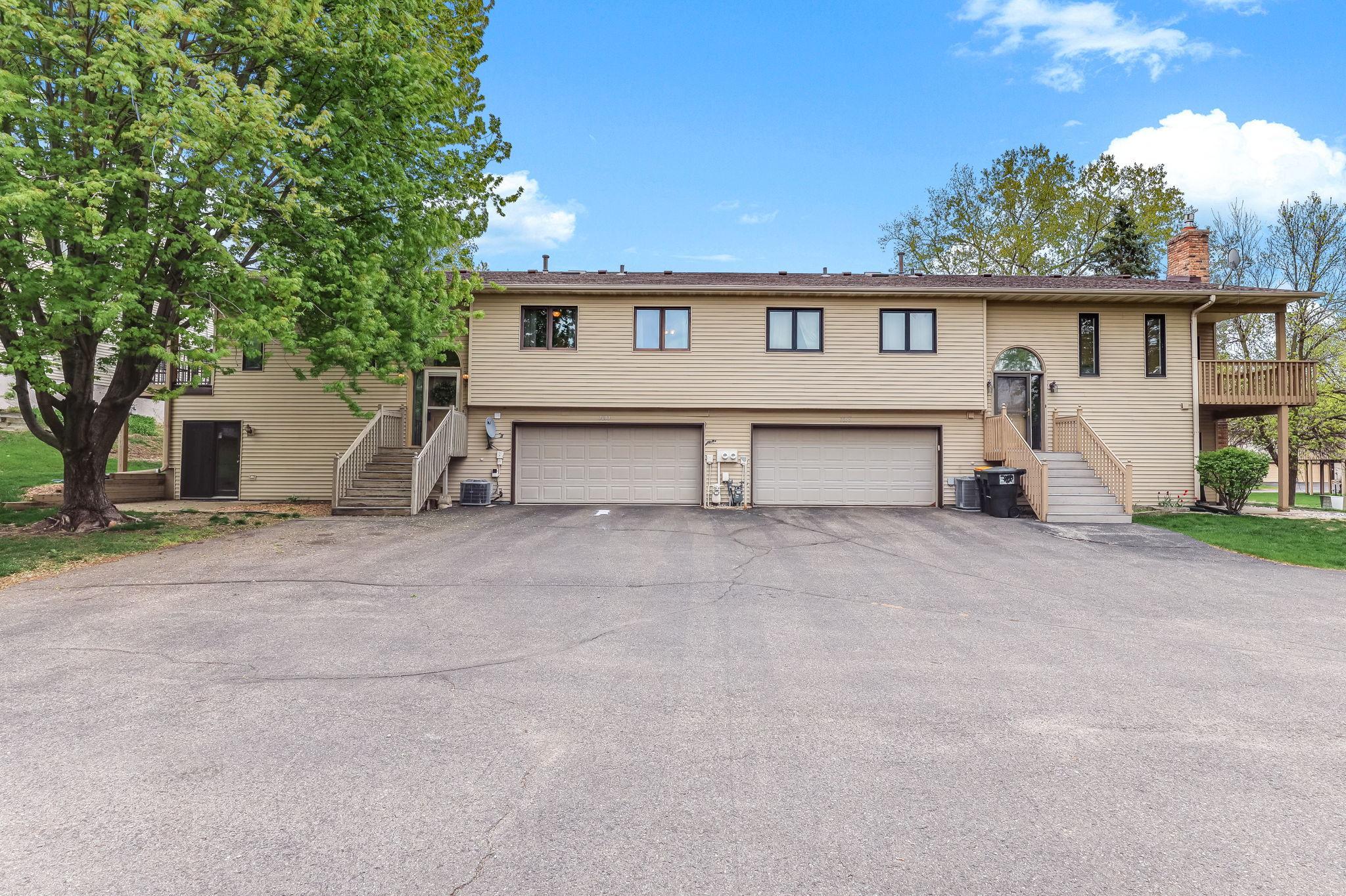 Front exterior of this updated Inver Grove Heights townhome featuring private entry, attached two-car garage, mature landscaping, and easy access to Highway 52, I-494, parks, trails, shopping, and dining in Dakota County.