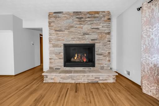 Gorgeous floor to ceiling stone gas fireplace is the showpiece of the living room