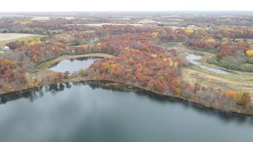 Aerial view from the lake shows the subject 4.9 acre lot to the right/north of the inland pond off of Ida and between the open field on right