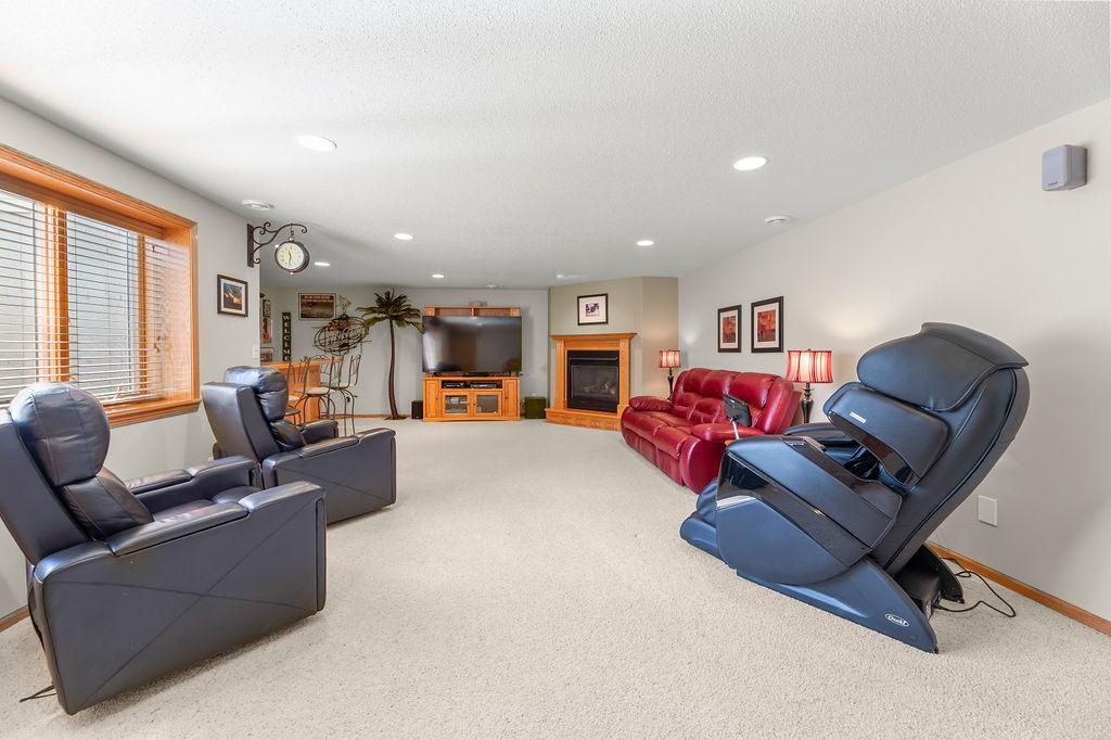 Basement family room with fireplace, recessed lighting, wet bar, & large egress window