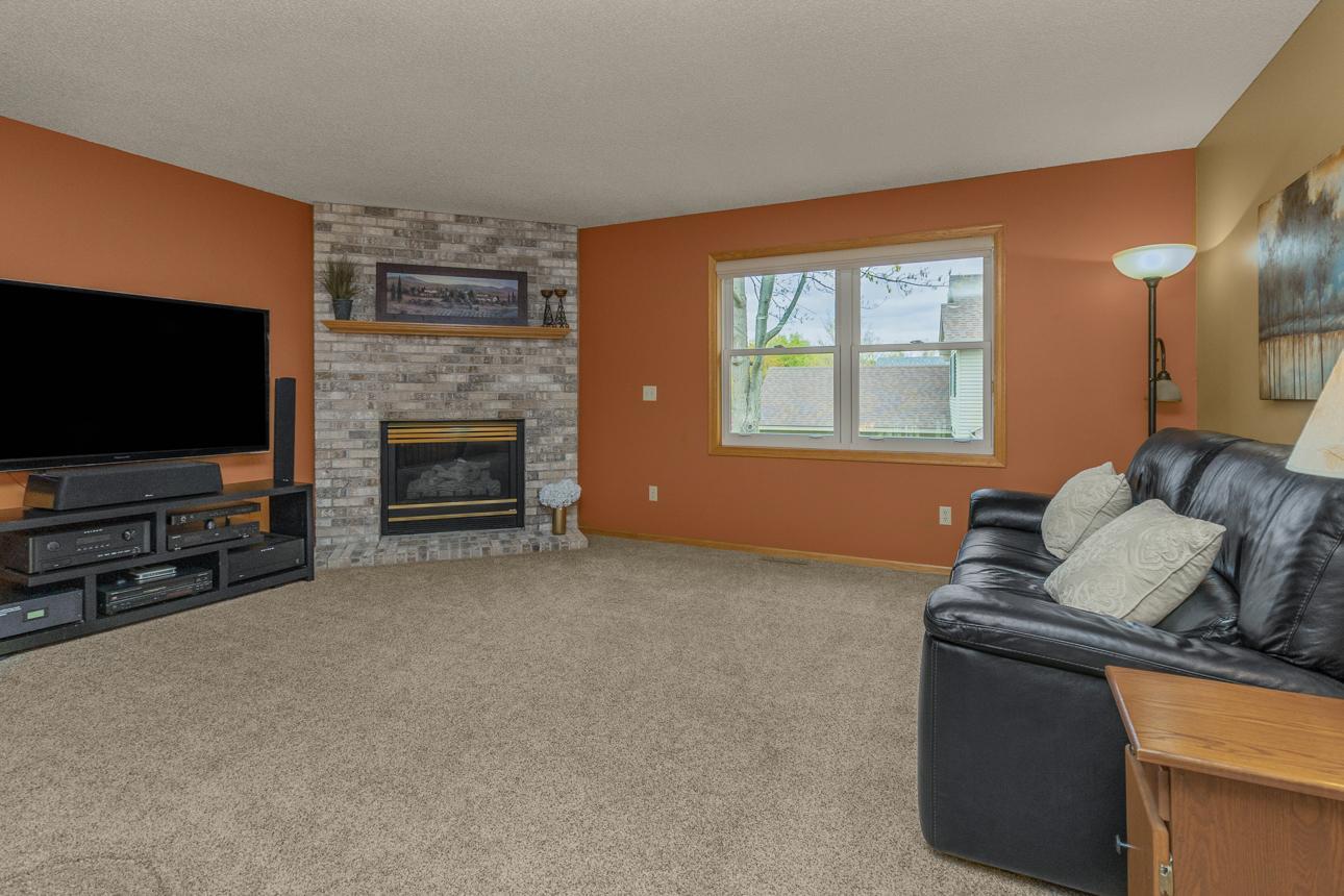 Upstairs, the living room includes gas fireplace with a classic brick mantel.