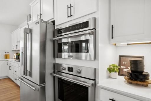 (Photo of a decorated model, actual homes finishes will vary) This stunning gourmet kitchen features a large center island, quartz countertops, LVP floors, stainless appliances and more!