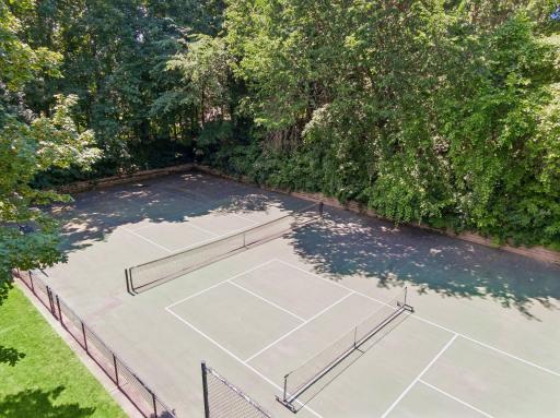 Tennis court with basketball hoop and pickleball net and lines