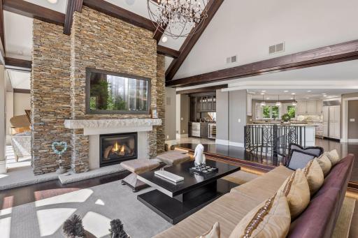 A dramatic living room showcasing soaring vaulted ceilings, expansive windows, and a stunning hand-laid slate fireplace surround