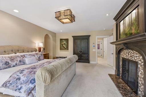 Primary suite features cozy gas fireplace, remote blinds, and access to the deck