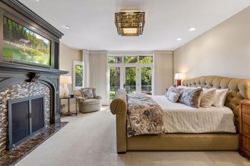 Primary suite features cozy gas fireplace, remote blinds, and access to the deck