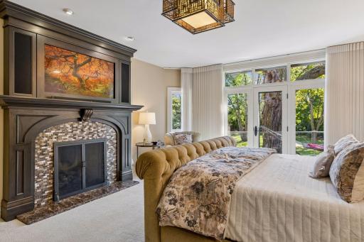Primary suite features cozy gas fireplace, remote blinds, and access to the deck