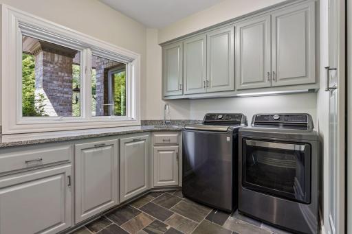 Main floor laundry with sink and plenty of cabinet space